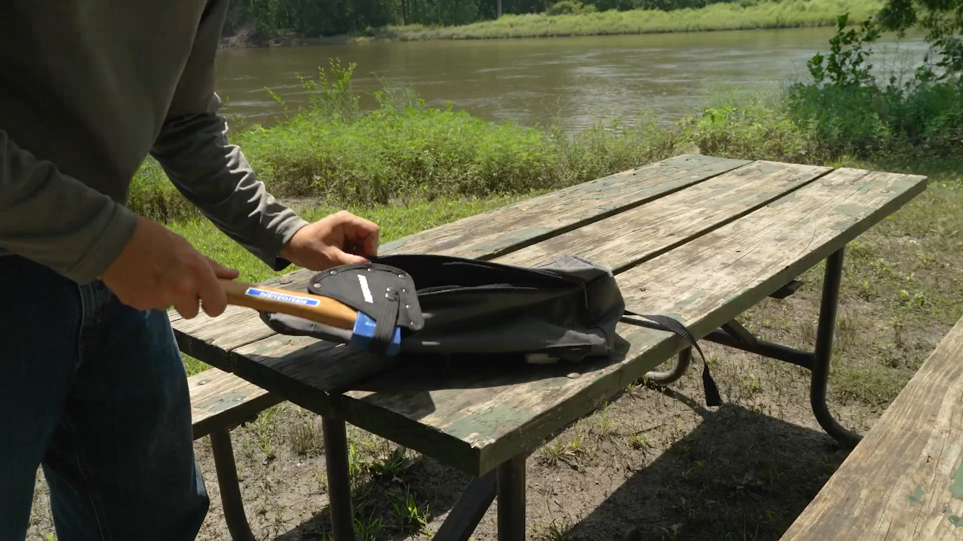 man storing Vaughan Camp Axe with Sheath into his backpack